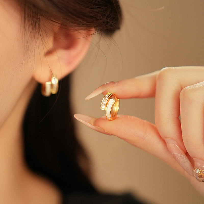 Gold huggie hoop earrings with ivory enamel arc and baguette CZ row — Luna Arc Enamel Baguette Huggies.
