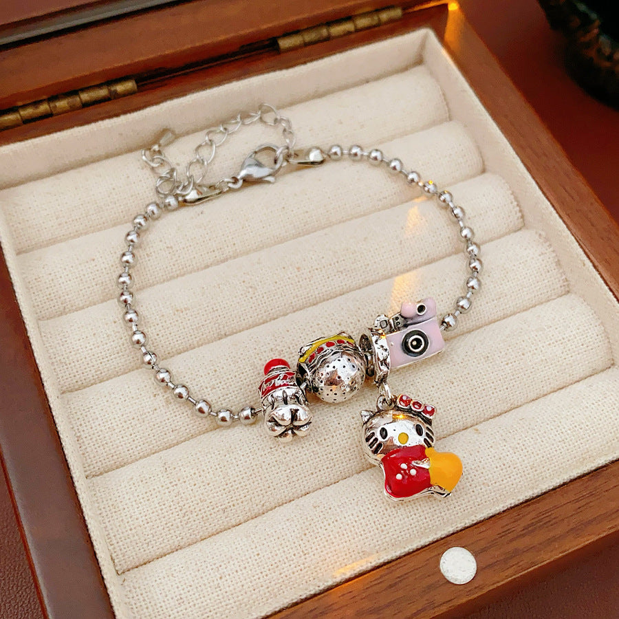 Kawaii Charm Story Bracelet with cartoon cat, burger, camera, and bell charms on silver-tone bead chain