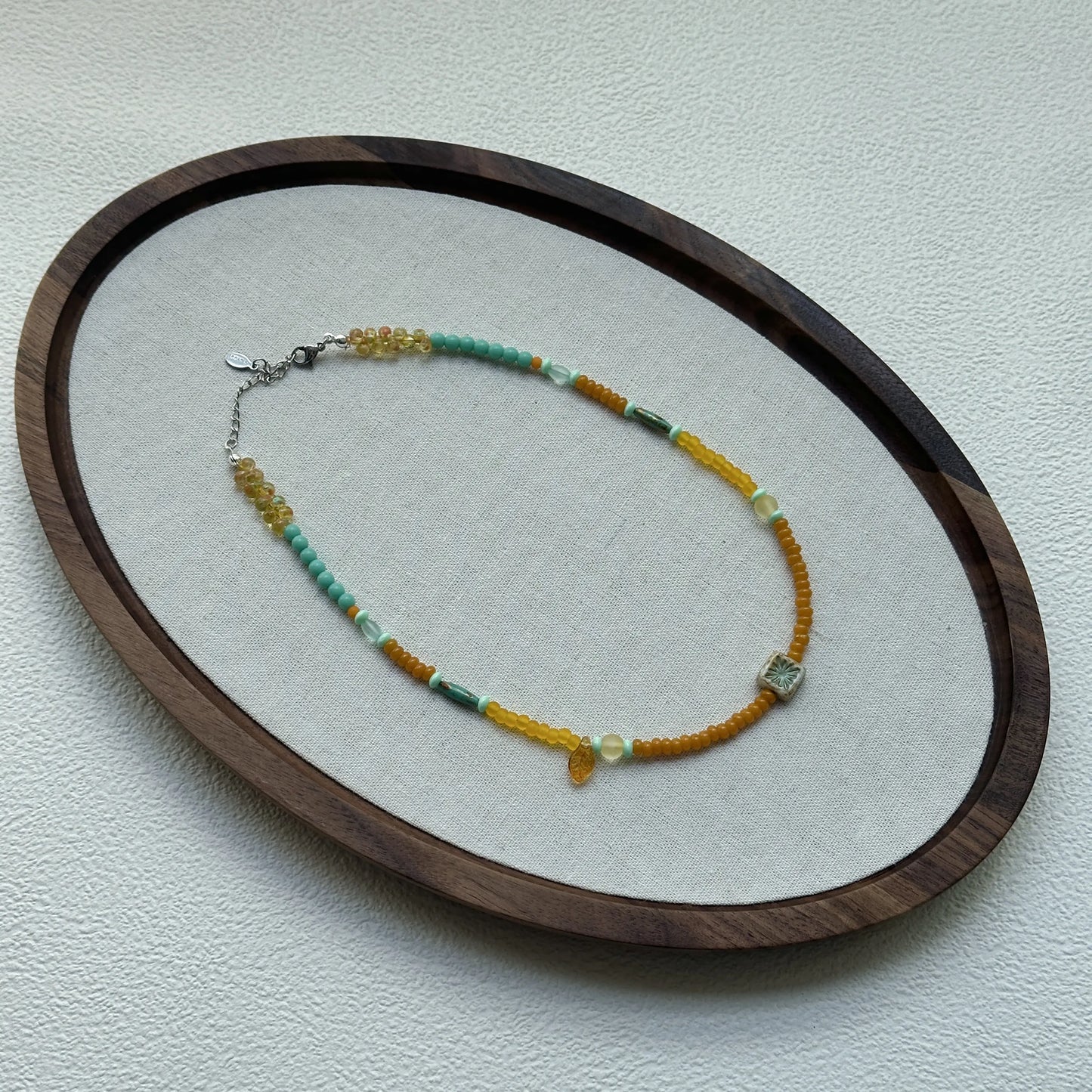 Citrus Lagoon Necklace displayed on an oval tray – bright citrus yellow and lagoon-green beads for a fresh coastal look