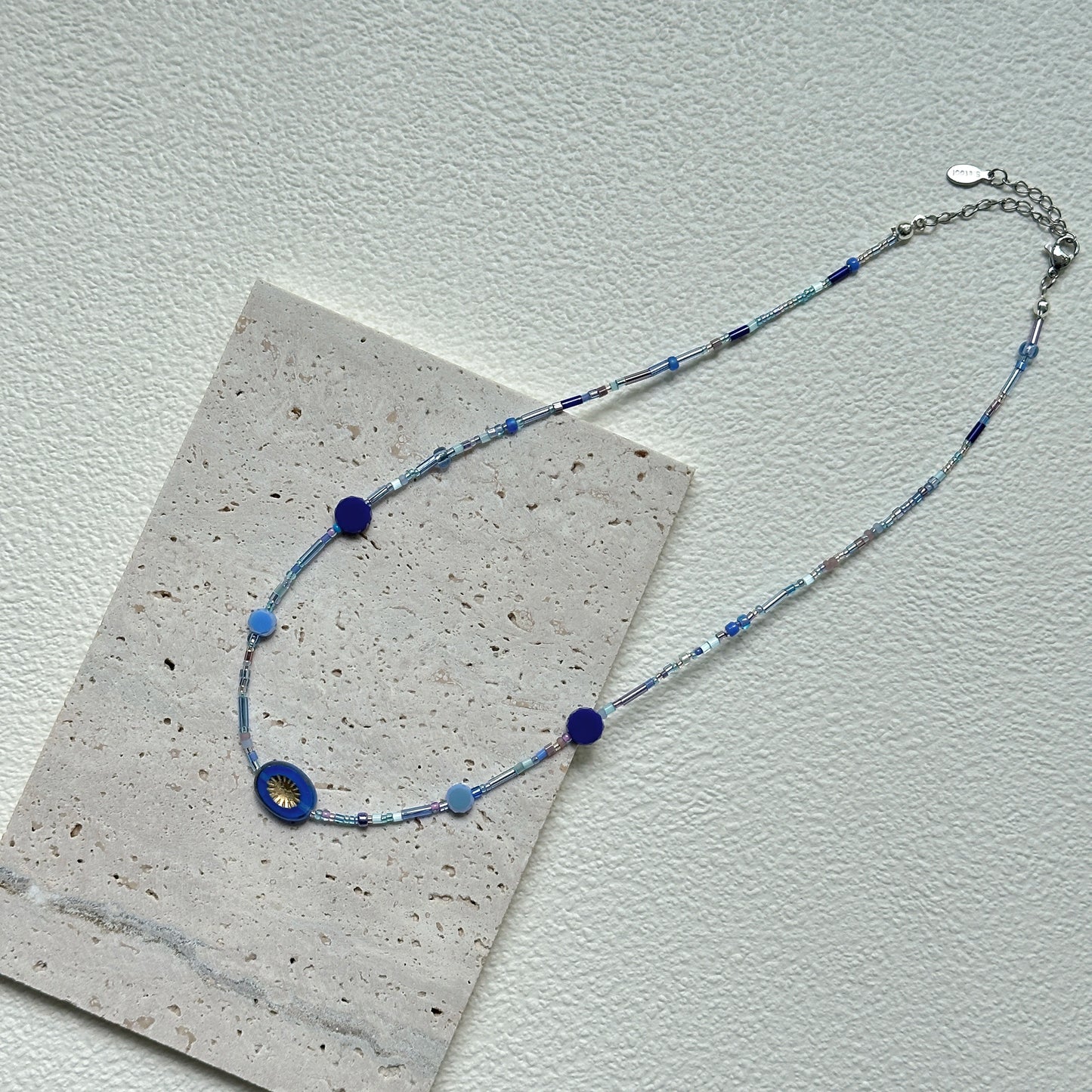 Handcrafted Celestial Wave Necklace laid flat showing silver, light blue, and dark blue beads