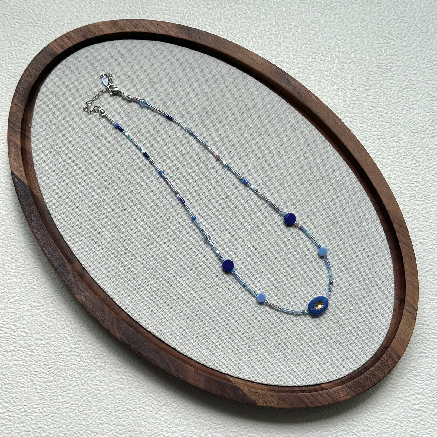 Handcrafted Celestial Wave Necklace laid flat showing silver, light blue, and dark blue beads2