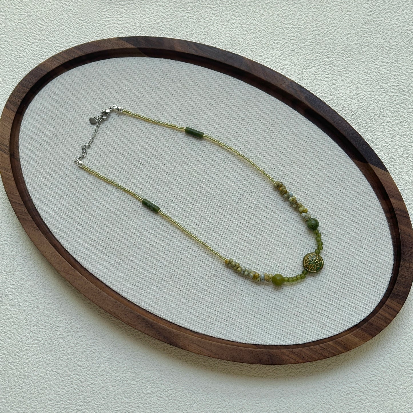 Green beaded luxury necklace on display stand