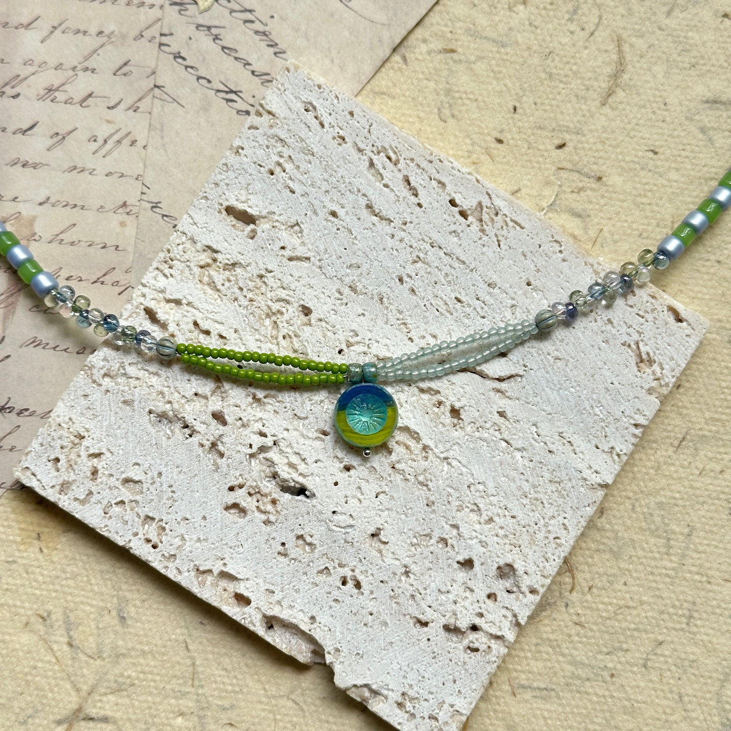 Citrus Wave Necklace — close-up highlighting striped beads and the wave medallion