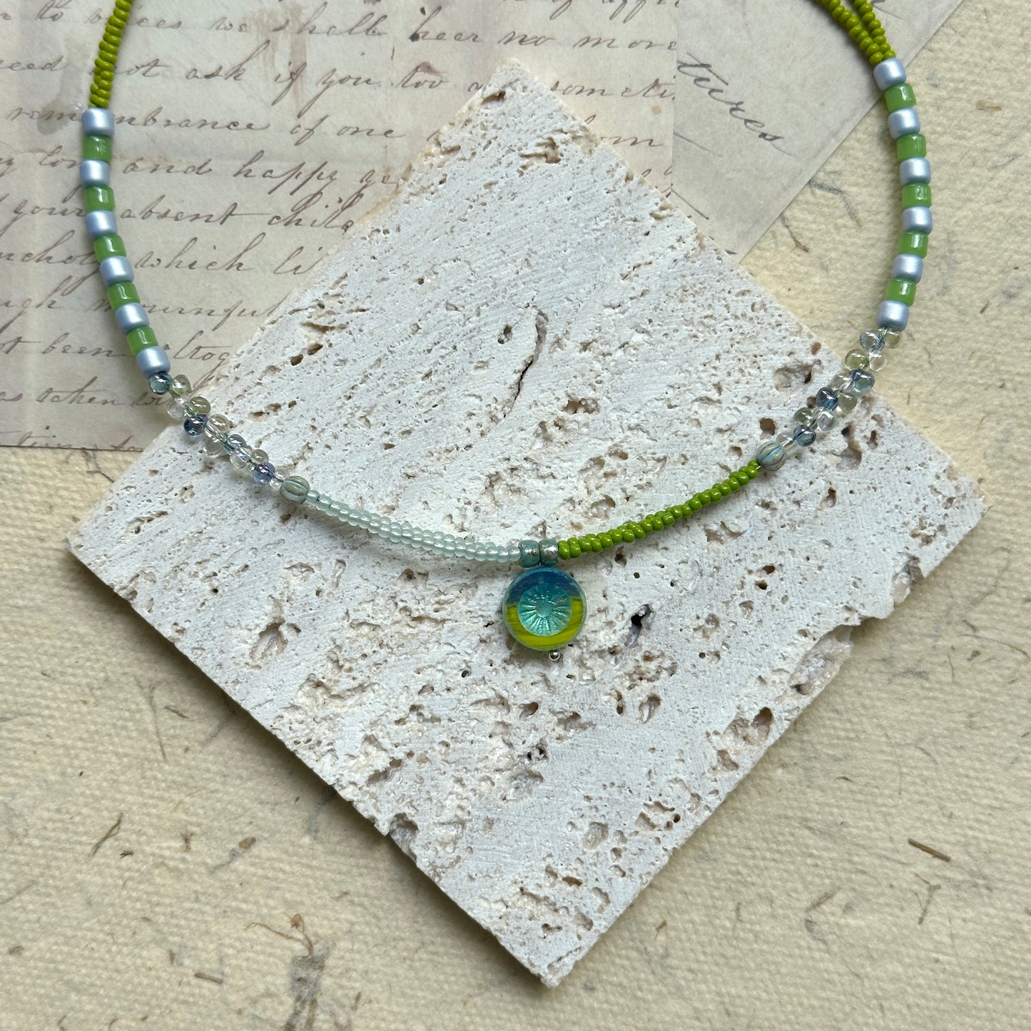 Citrus Wave Necklace — close-up highlighting striped beads and the wave medallion1