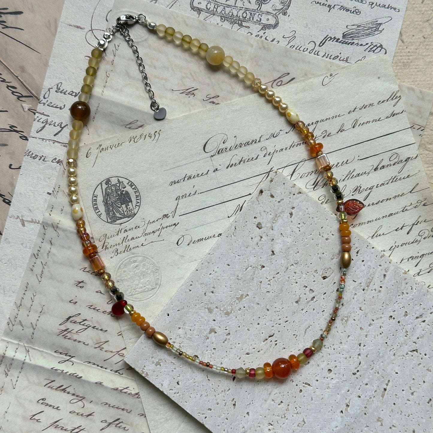 Golden Nectar Necklace flat lay with radiant amber cluster, gold bead mix, and delicate leaf accent