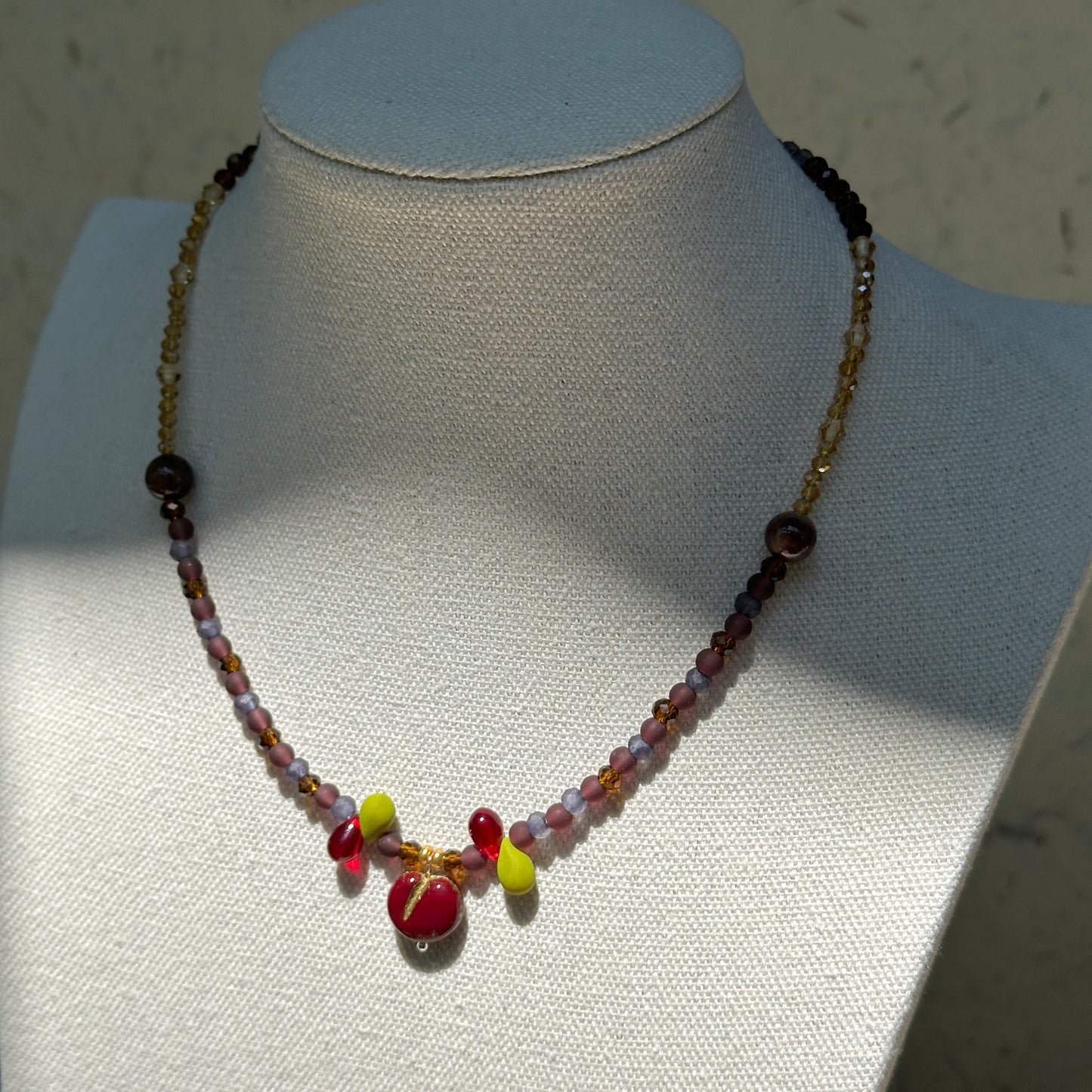 Model wearing Crimson Apple Charm Necklace, cozy evening palette