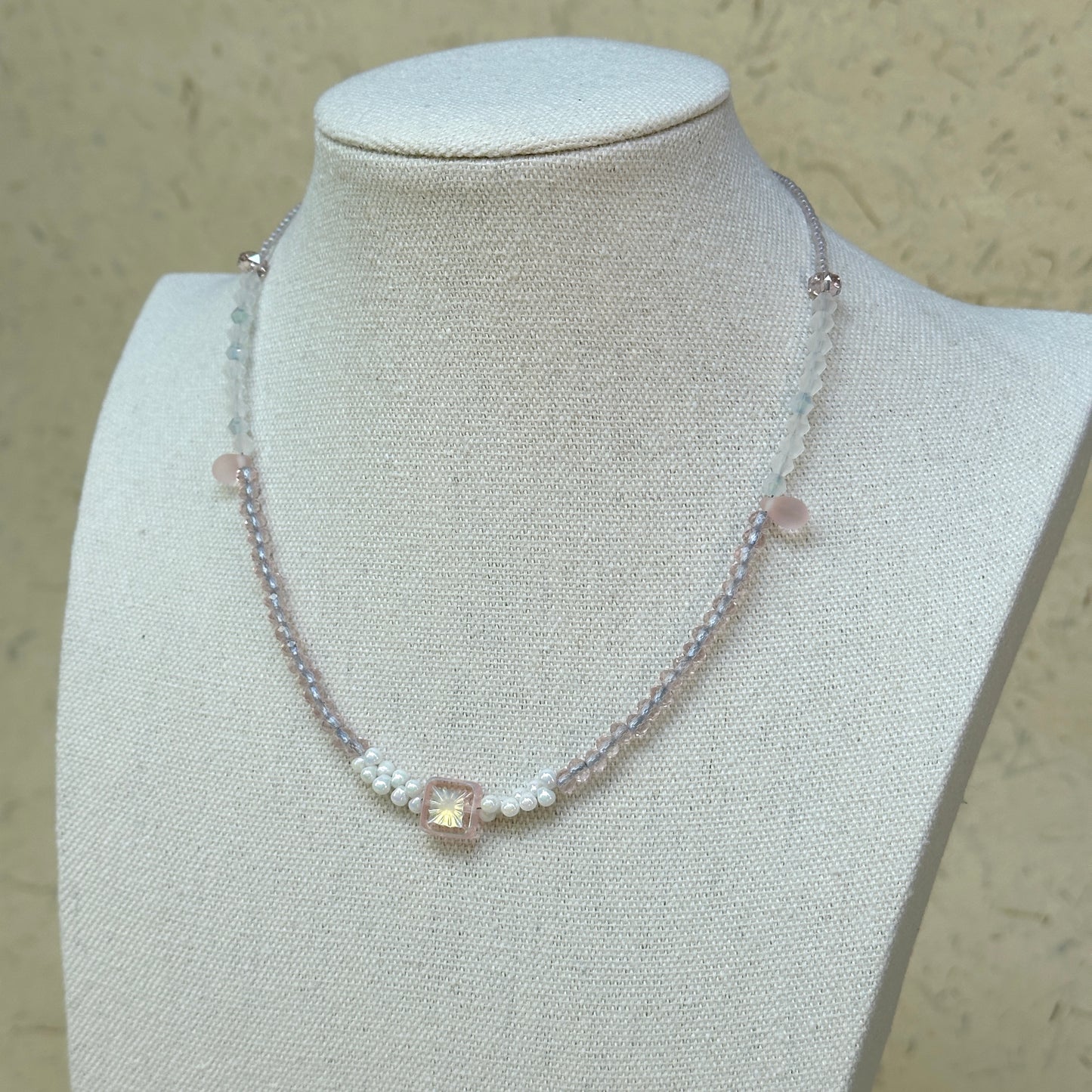 Blush Crystal Necklace worn on bust, highlighting square-cut crystal centerpiece with airy blush pink and white bead palette