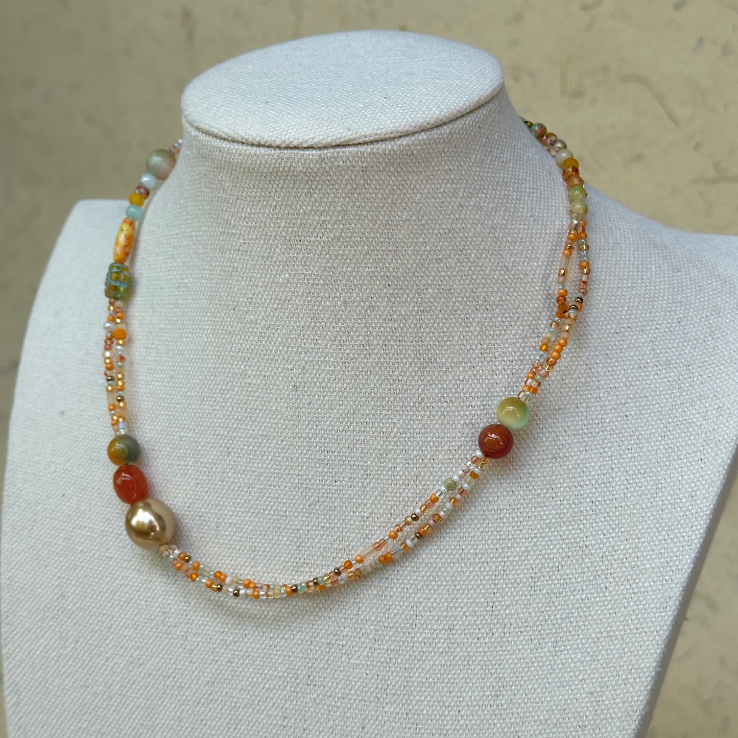 Golden Ember Necklace worn on bust, highlighting elegant yet minimal silhouette with fiery amber and gold beadwork