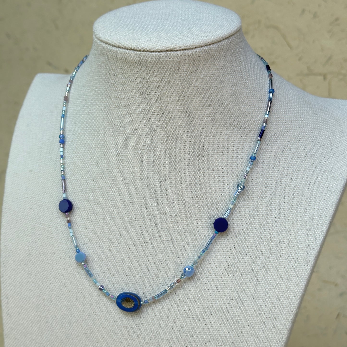 Celestial Wave Necklace worn on bust, showcasing delicate blue seed beads and celestial-inspired focal pendant