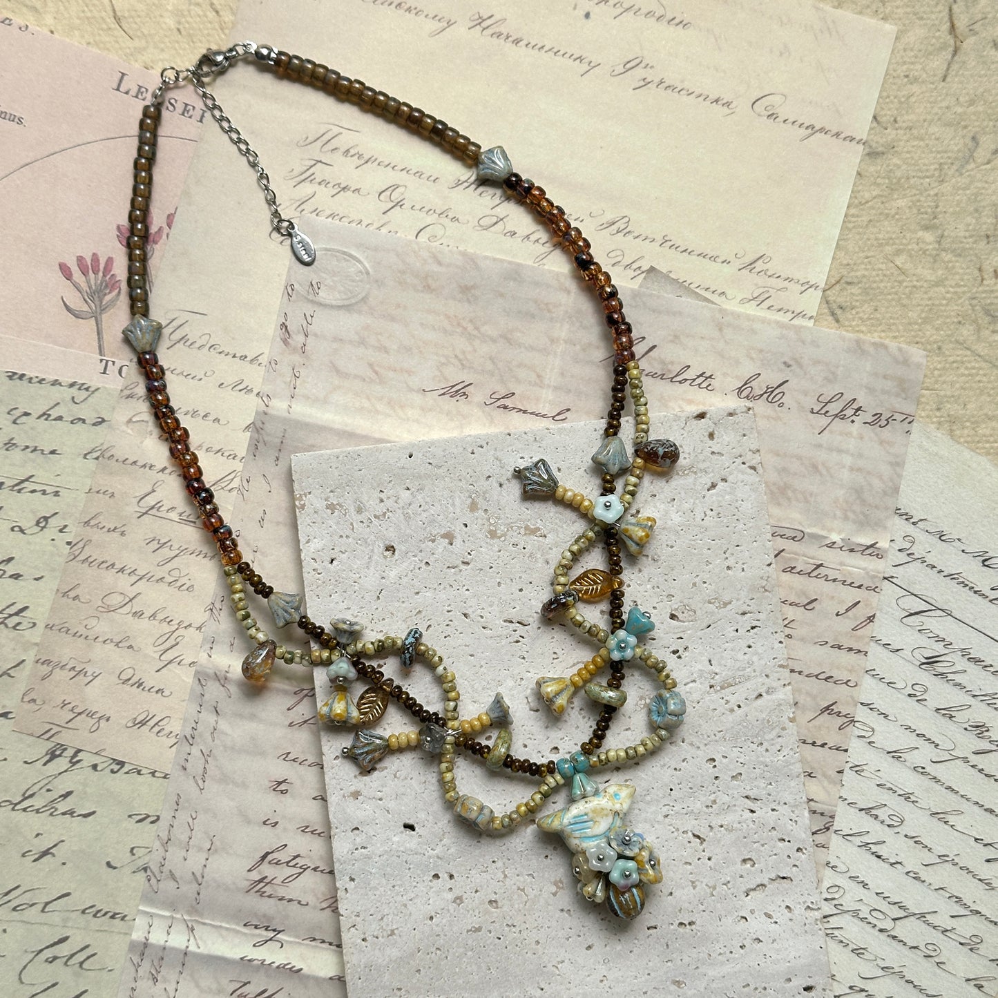 Vintage-inspired Autumn Whisper Necklace, handcrafted with amber glass, natural stones, and muted blue beads, lightweight cascading design flat display.