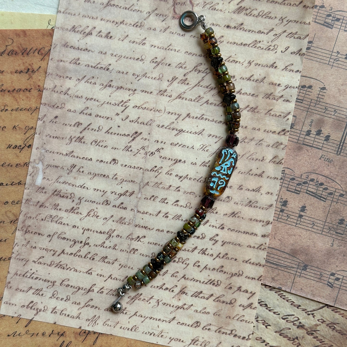 Close-up of etched cartouche-style bead with patina finish