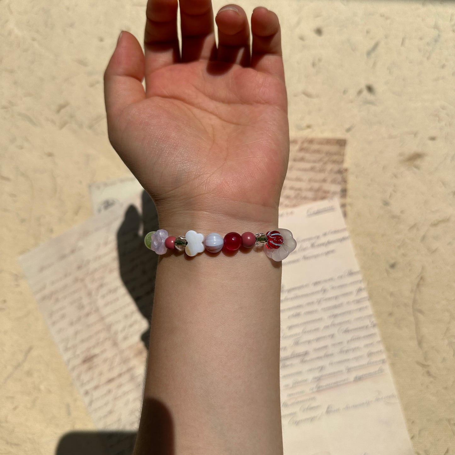 Nature-inspired bracelet with red, green, and lilac glass accents