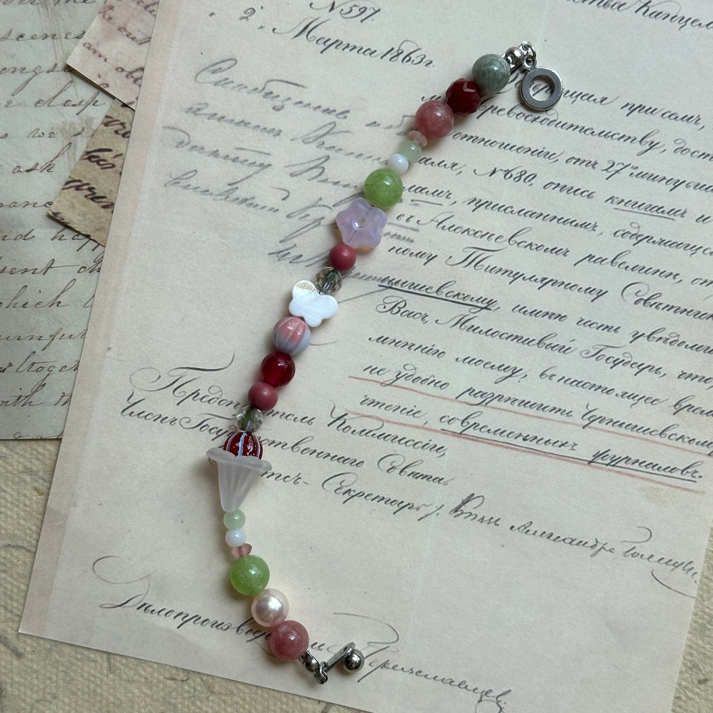 Handcrafted bracelet featuring blossoms, pearls, and pastel tones