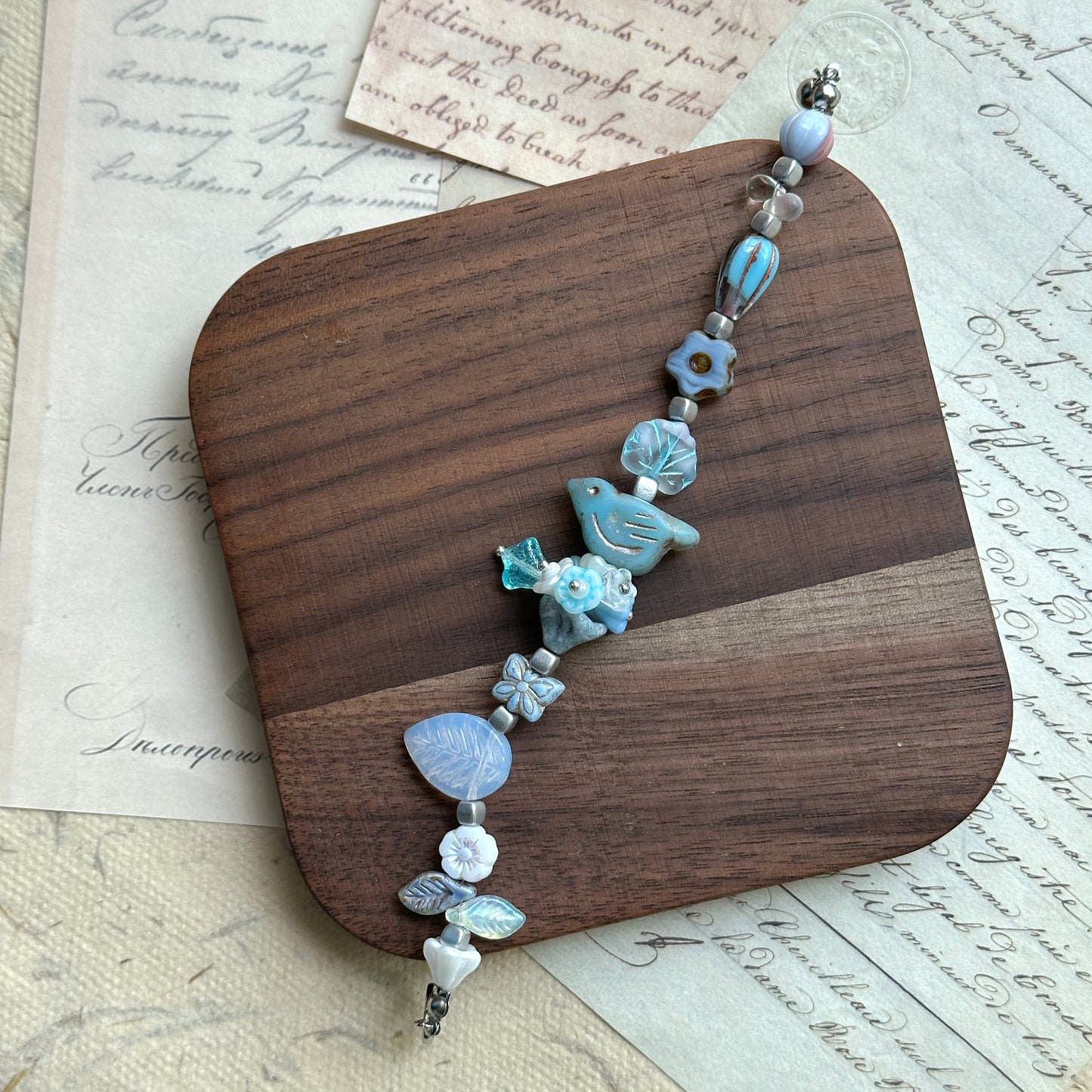 Handcrafted bracelet featuring bluebird charm and star accents