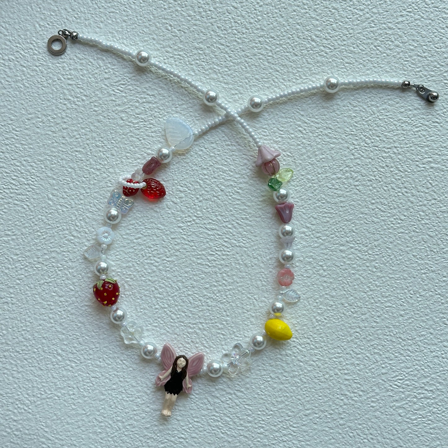 Close-up of pink-wing fairy pendant centerpiece on necklace