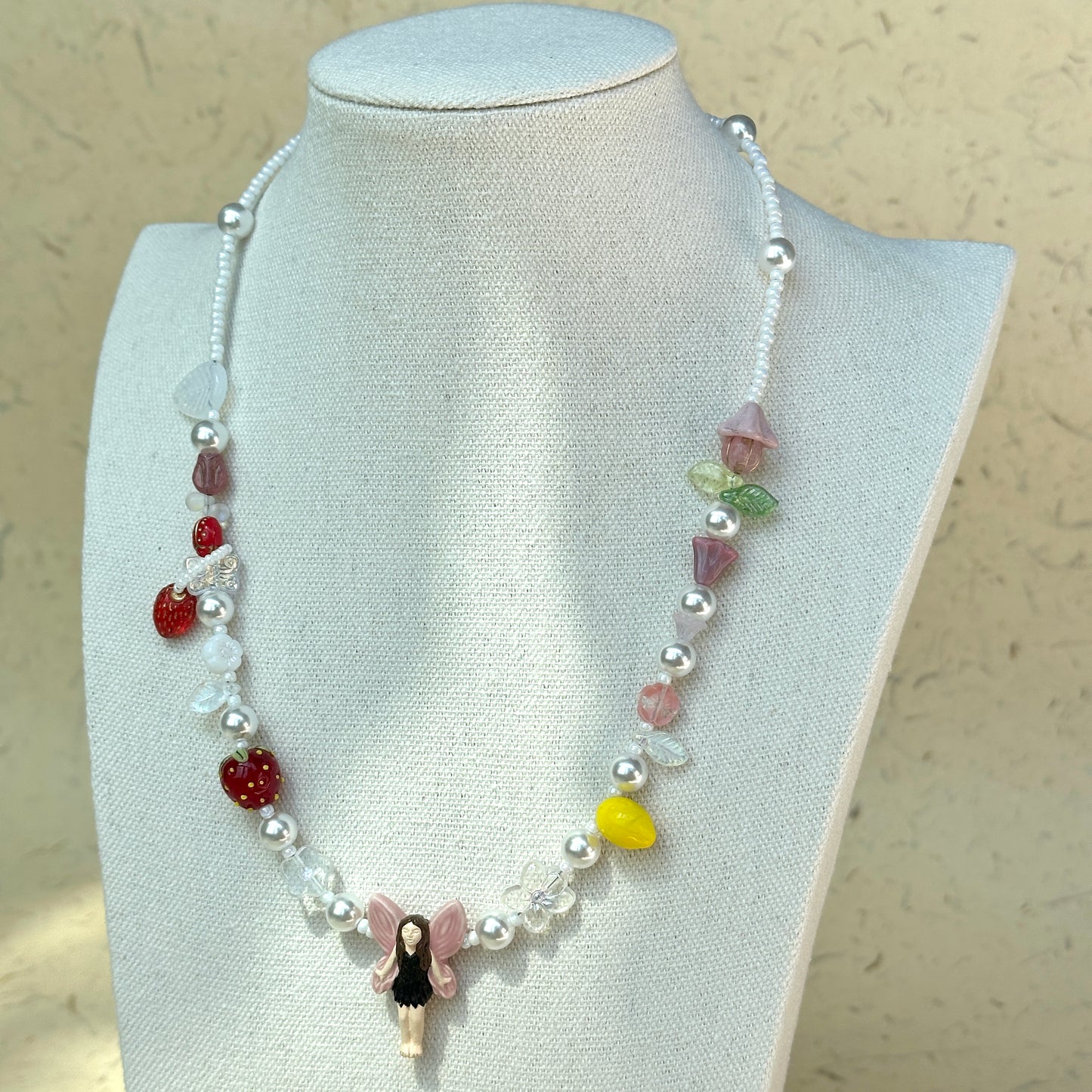 Full view of Fairy Garden Necklace displayed on beige jewelry stand