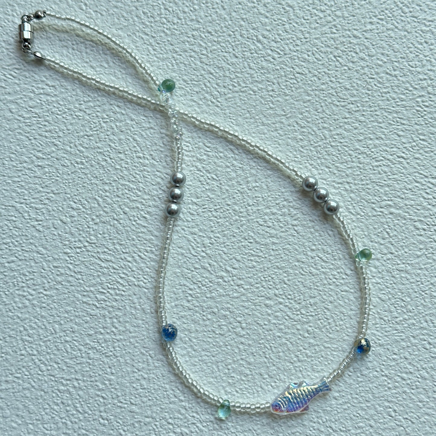Close-up of shimmering fish bead with white seed beads