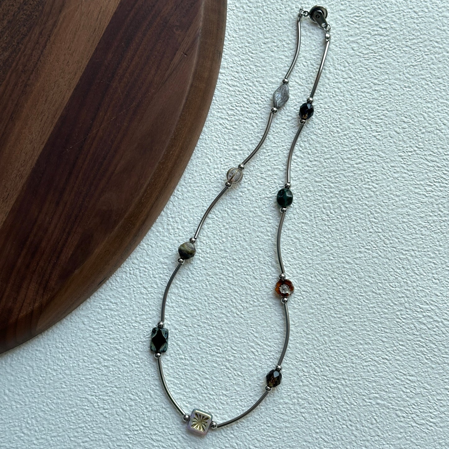 Close-up of square silver-tone bead with floral motif