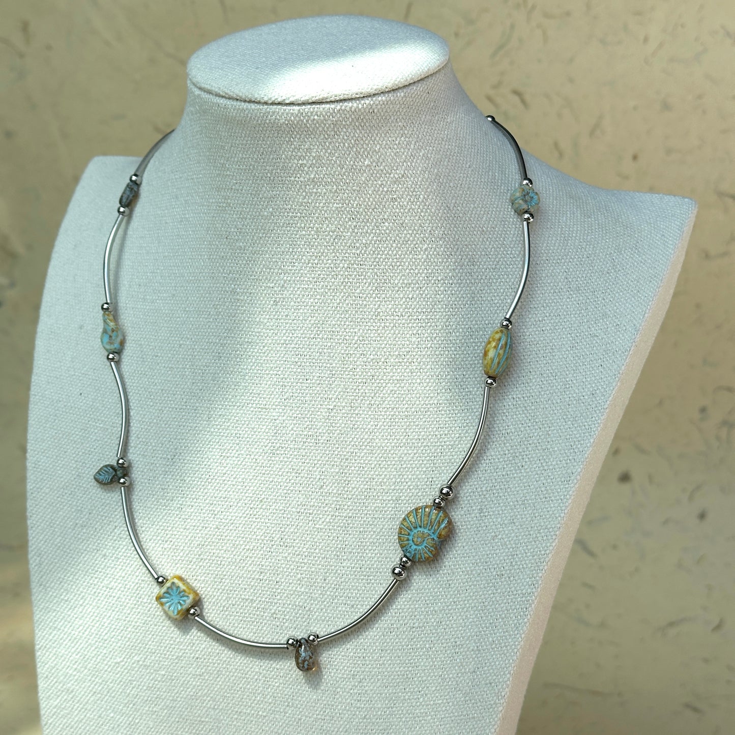 Curved silver-tone links with patterned glass beads