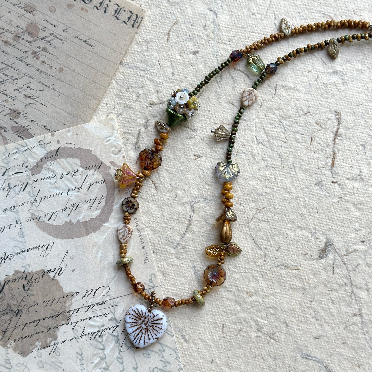 Rustic handcrafted necklace in earthy green, gold, and amber hues