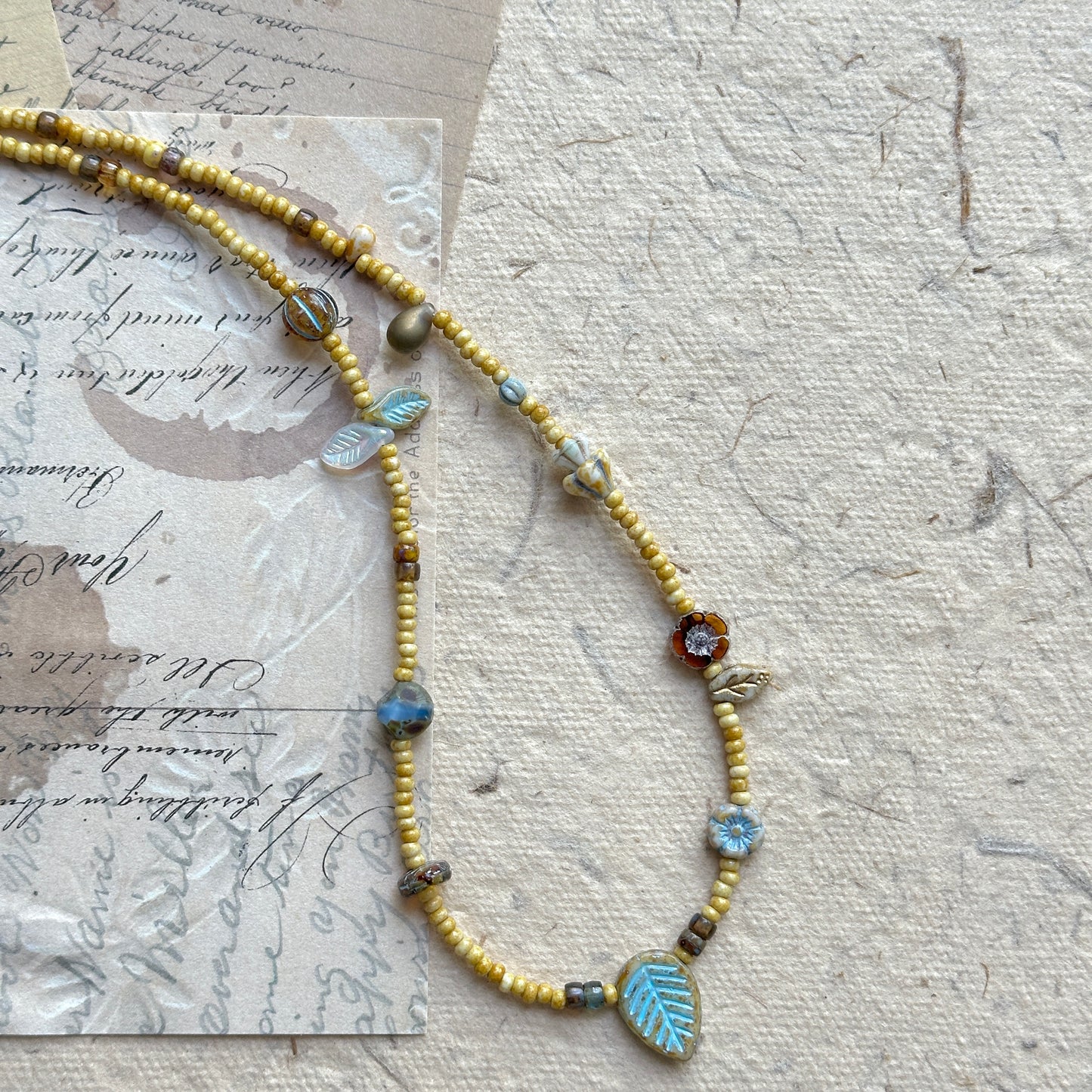Close-up of turquoise leaf focal bead with rustic golden strand