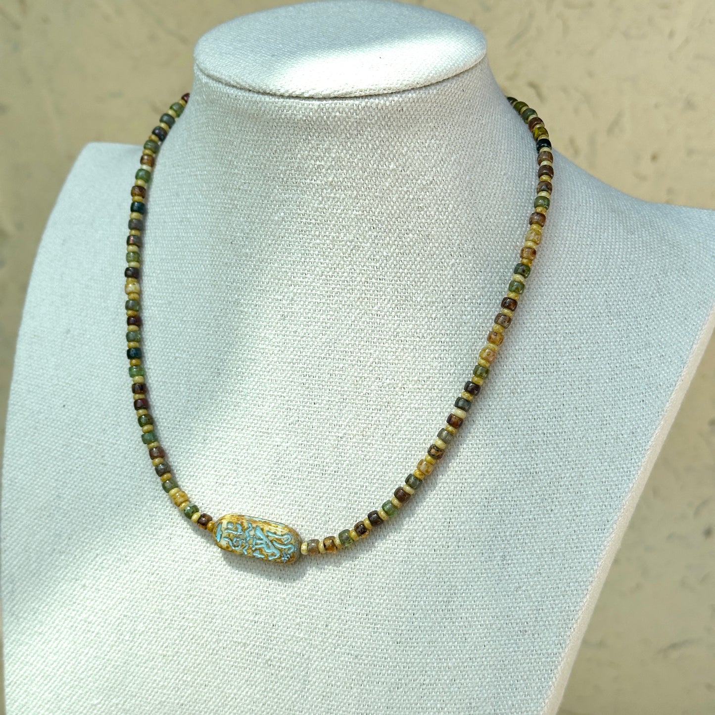 Rustic handcrafted necklace with brown, amber, and green beads