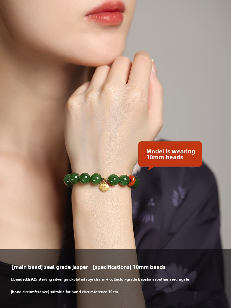 Green Hetian (nephrite) jade bead bracelet with red spacer and gold-tone charm