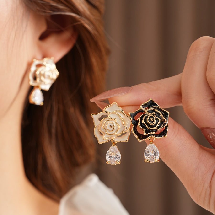 Gold-tone rose stud earrings with ivory and black enamel petals plus teardrop zircon dangles — Gilded Rose Teardrop Studs.