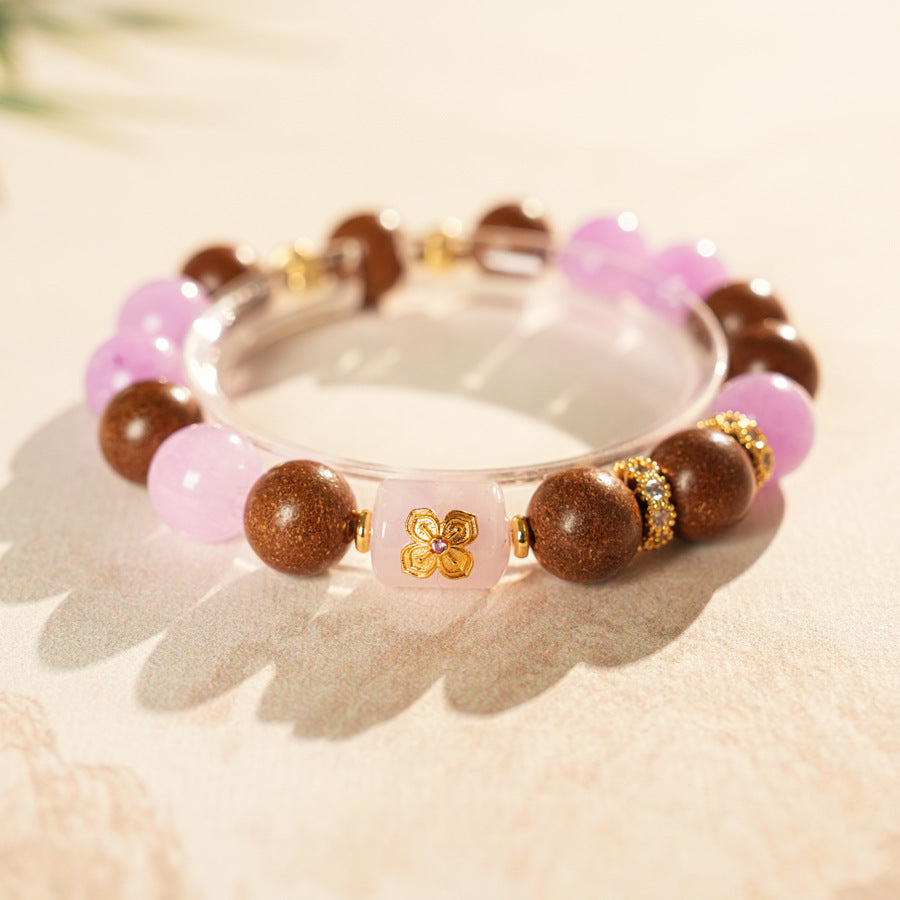 Handcrafted bracelet with pink and lavender crystals paired with sandalwood and gold floral accents — Lavender Serenity Bracelet by Glazenya.