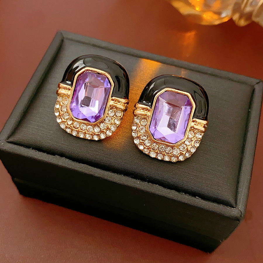 Black enamel stud earrings with amethyst-tone crystal and rhinestone frame — Midnight Amethyst Radiance Earrings.