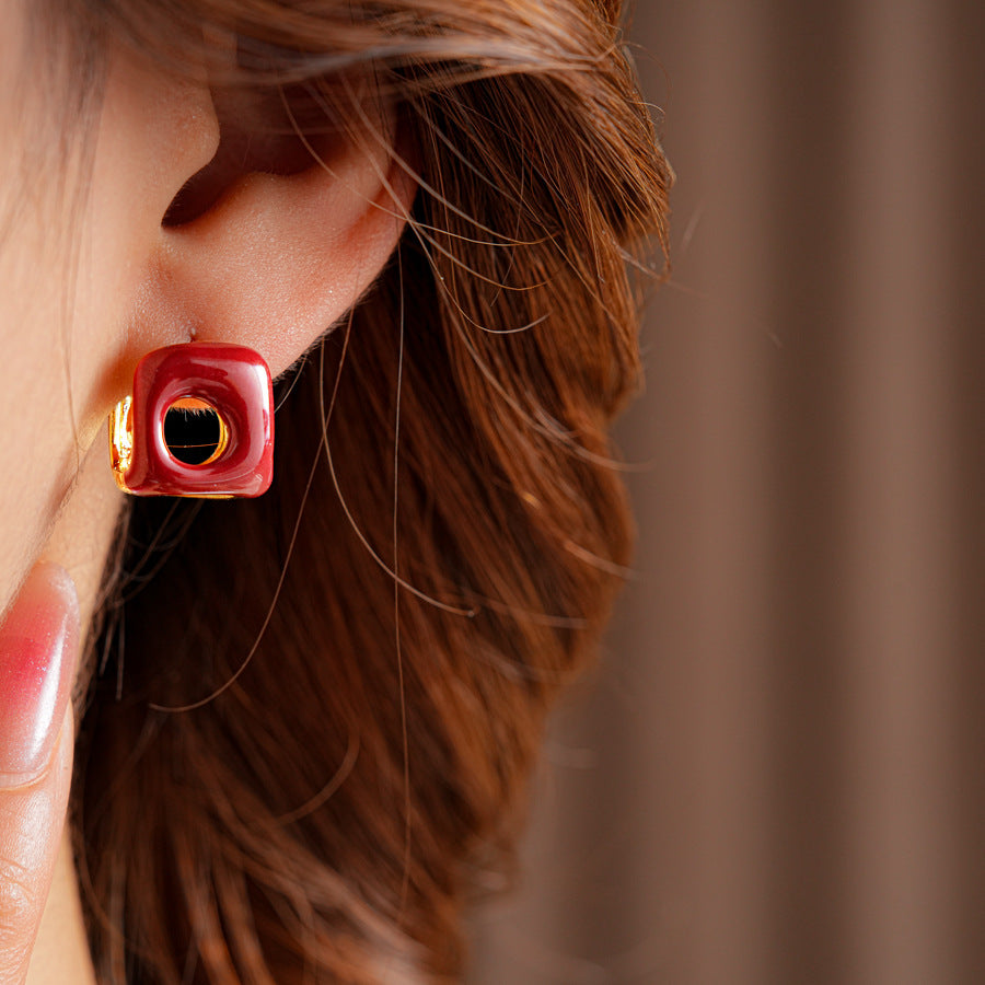 Square pillow ear cuffs with glossy enamel shell and mirrored gold core in white, red, and coffee — Gilded Core Pillow Ear Cuffs.