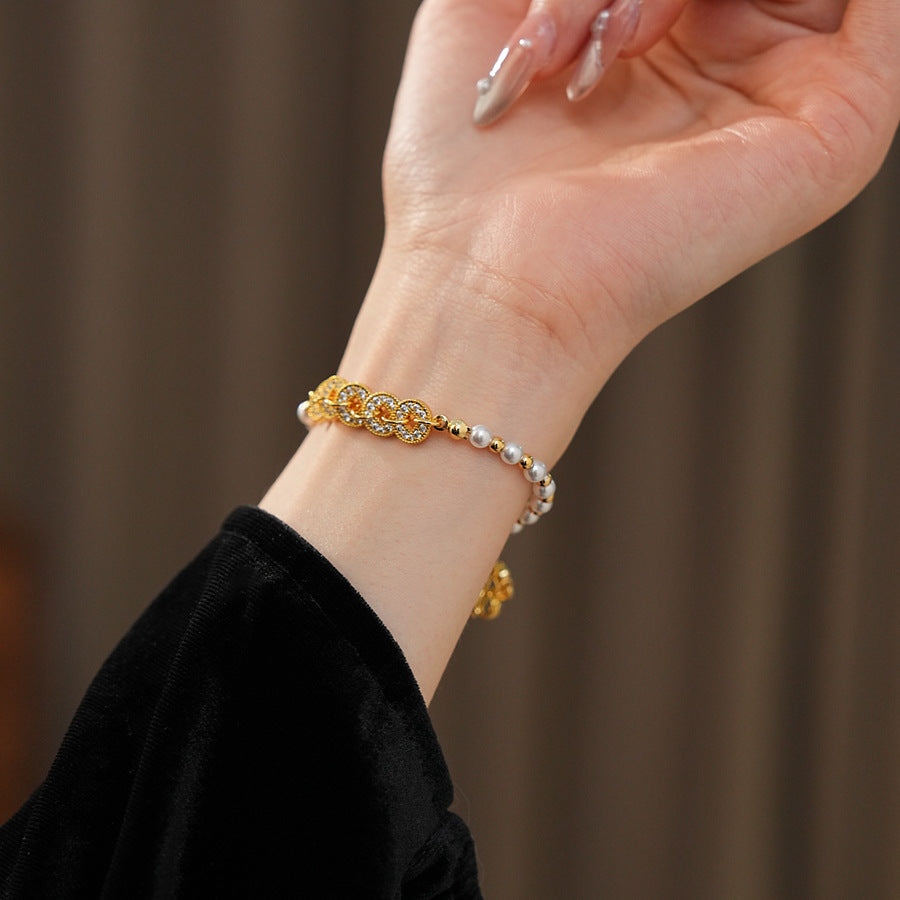 Gold link and pearl chain bracelet with zircon accents on green velvet background – Celestial Pearl Chain Bracelet by Glazenya