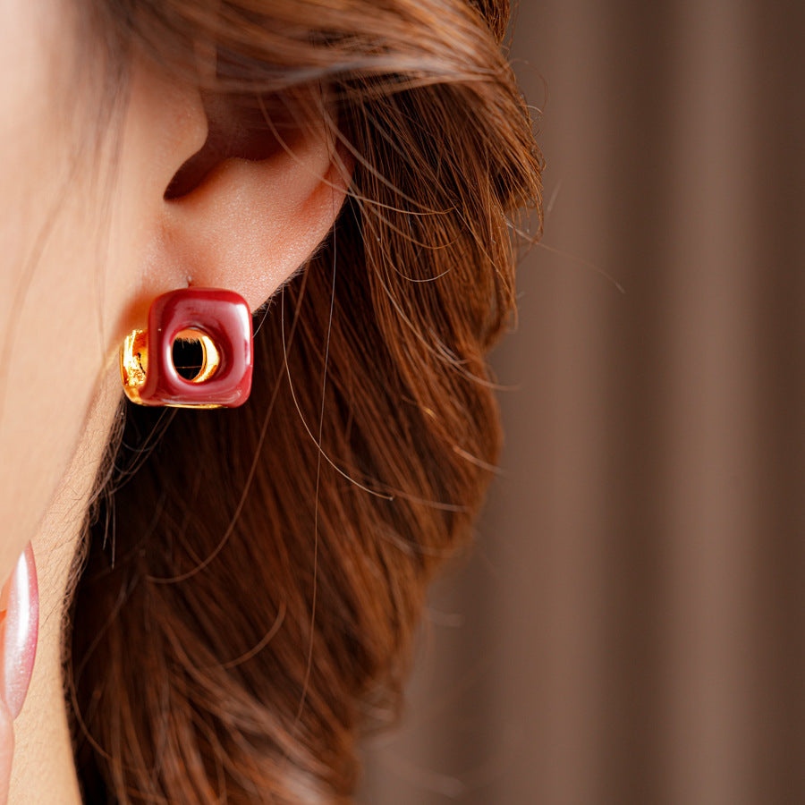 Square pillow ear cuffs with glossy enamel shell and mirrored gold core in white, red, and coffee — Gilded Core Pillow Ear Cuffs.