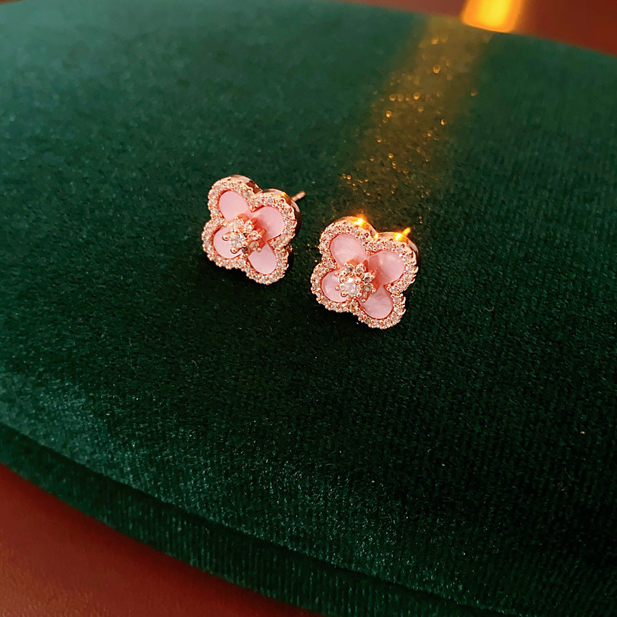 Clover jewelry collection — earrings and necklace displayed together