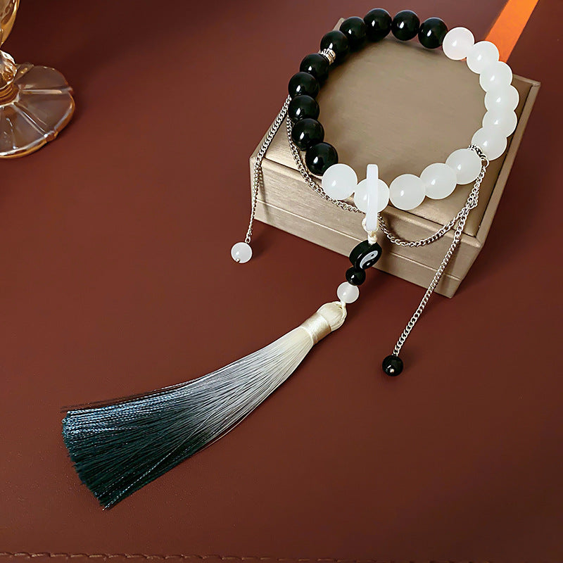 Black and white colored-glass beaded bracelet with yin-yang charm and gradient tassel — Yin-Yang Serenity Tassel Bracelet by Glazenya.