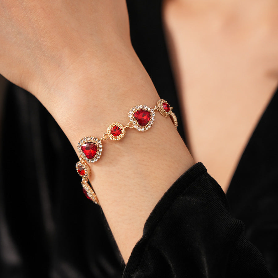 Crimson Heart Luxe Collection with red heart gemstone necklace, bracelet, and earrings, accented with pavé details