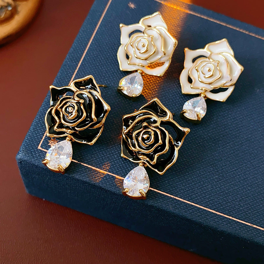Gold-tone rose stud earrings with ivory and black enamel petals plus teardrop zircon dangles — Gilded Rose Teardrop Studs.