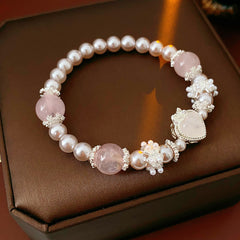 Rosy Heart Pearl Bracelet with pink crystal heart charm and luminous pearls on black background