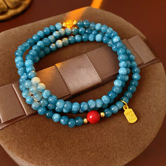Blue multi-wrap beaded bracelet with red accent bead and gold charm — Azure Charm Wrap Bracelet.