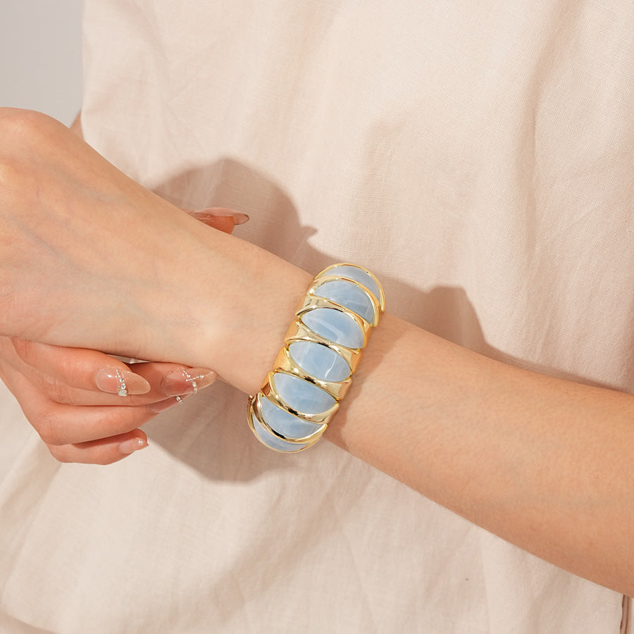 Gold-tone segmented bangle with marbled acrylic dome tiles — Gilded Capsule Resin Bangle.