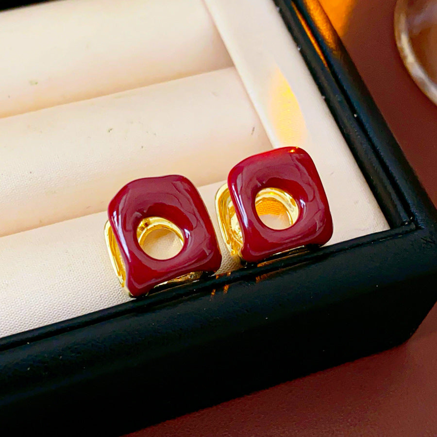 Square pillow ear cuffs with glossy enamel shell and mirrored gold core in white, red, and coffee — Gilded Core Pillow Ear Cuffs.