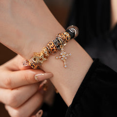 Leopard Cross Luxe Bracelet with leopard-patterned beads, zircon accents, black 8-ball bead, and cross pendant on gold chain