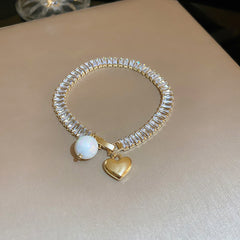 Gold-plated bracelet collection with pearls, cat’s eye stones, and floral motifs