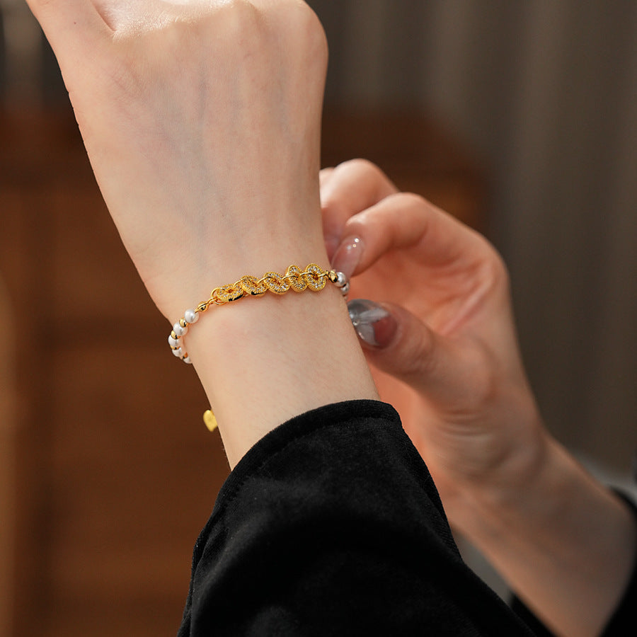 Gold link and pearl chain bracelet with zircon accents on green velvet background – Celestial Pearl Chain Bracelet by Glazenya