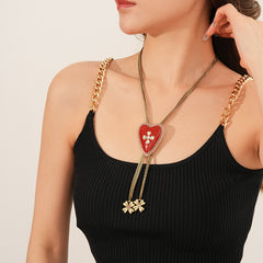 Lariat necklace with beaded-edge heart pendant and twin tassel blossoms on model — Regal Heart Tassel Lariat Necklace.
