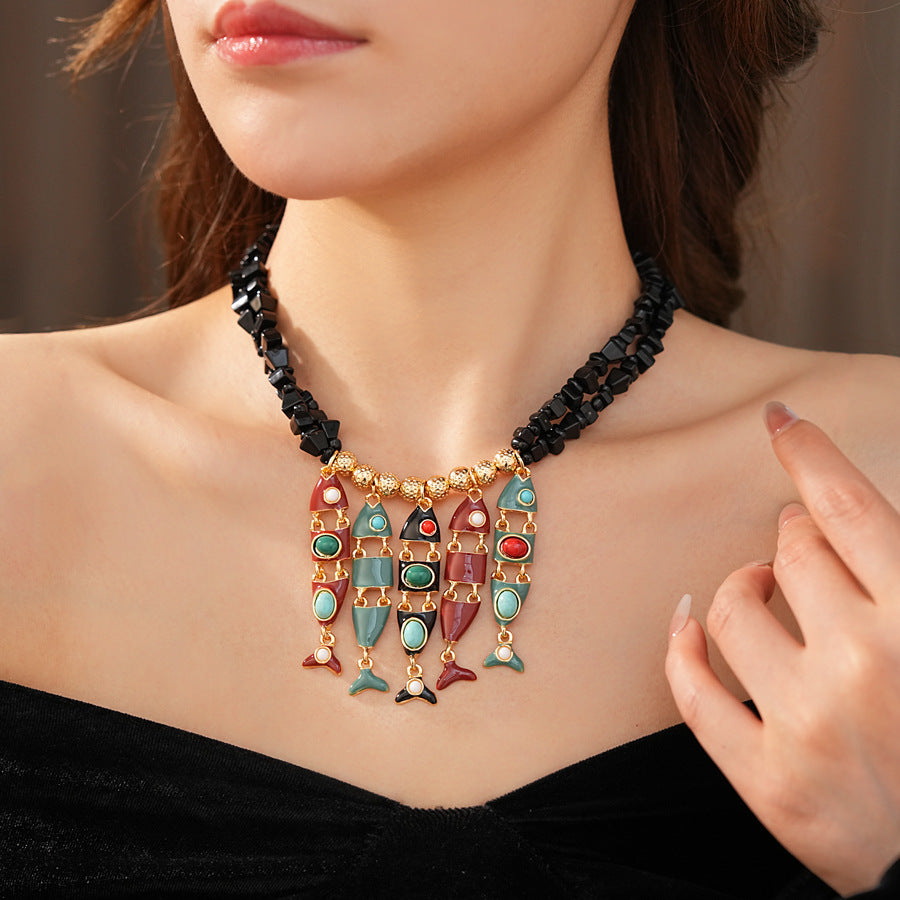 Statement necklace with articulated fishbone fringe, gold beads, and red or black chip strands — Kaleido Fishbone Fringe Necklace.