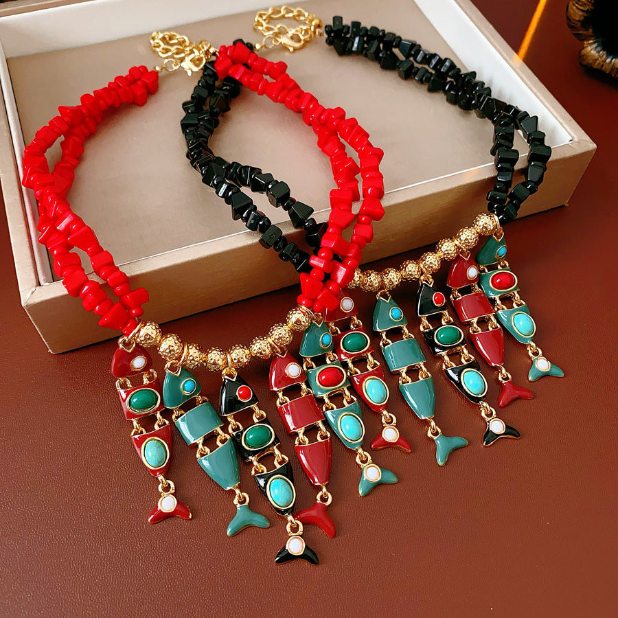 Statement necklace with articulated fishbone fringe, gold beads, and red or black chip strands — Kaleido Fishbone Fringe Necklace.