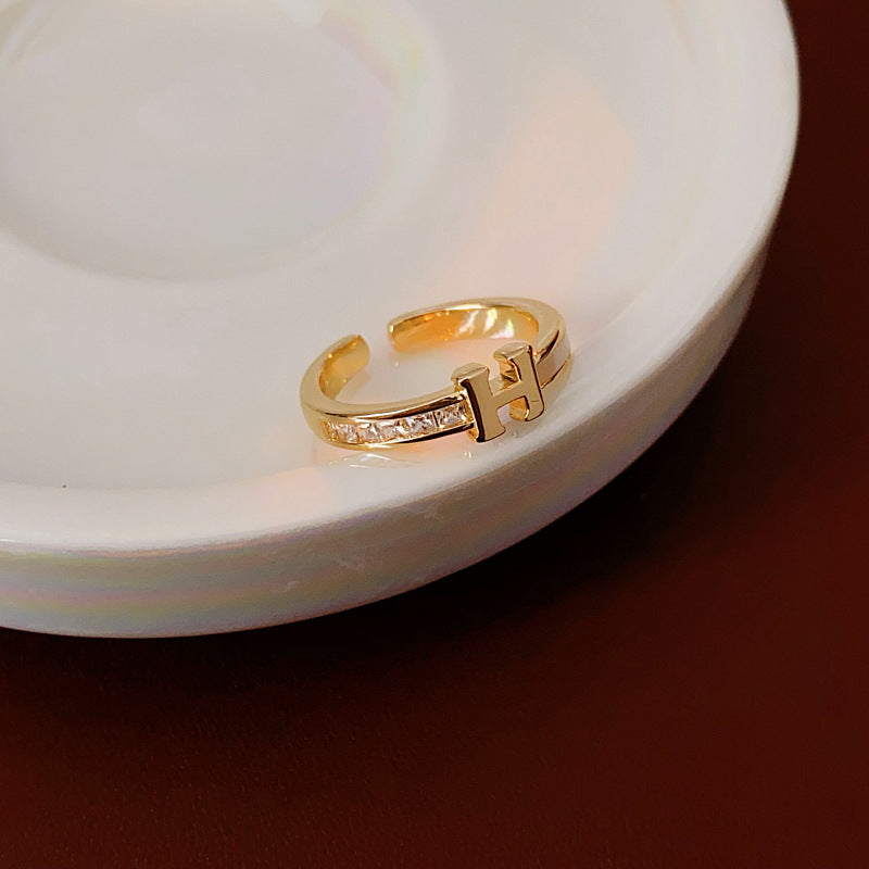 Gold-tone open ring with initial bridge and channel-set pavé cubic zirconia — Lumière Initial Pavé Open Ring.