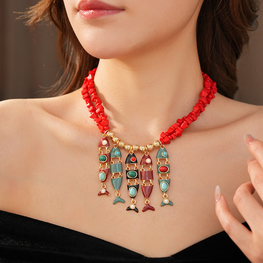 Statement necklace with articulated fishbone fringe, gold beads, and red or black chip strands — Kaleido Fishbone Fringe Necklace.