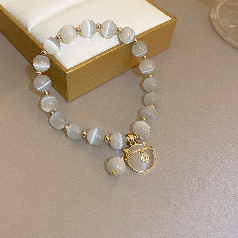 Gold-plated bracelet collection with pearls, cat’s eye stones, and floral motifs